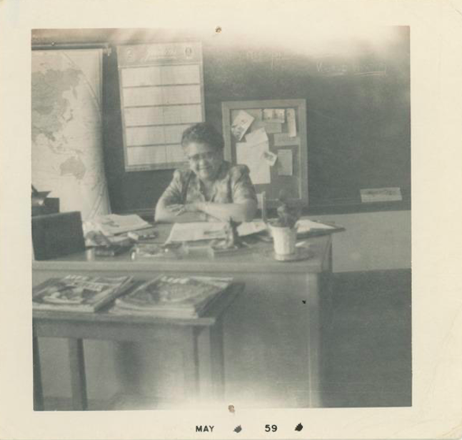 Yolande Du Bois seated at desk in Dunbar High School, May 1959. Du Bois Family Papers (MS 1143). Special Collections and University Archives, University of Massachusetts Amherst Libraries. 